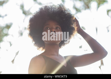 Giovane africano donna americana shot dal di sotto, fiducioso look, determinata Foto Stock
