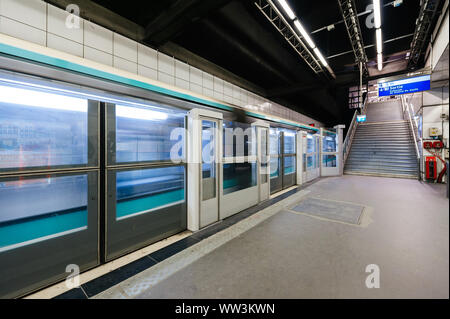 Parigi, Francia - Luglio 14, 2011: veloce della metropolitana Parigina treno passa dietro la barriera di sicurezza alla piattaforma della metropolitana Parigina stazione della metropolitana Foto Stock