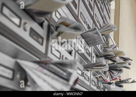 Metallo moderno le caselle di posta, trabocca di volantini. Ideale per i concetti. Foto Stock