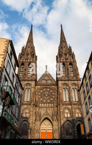 Bella e imponente cattedrale di Clermont Ferrand in Francia, realizzato da scure rocce vulcaniche alleggerire dal tramonto dorato della luce del sole Foto Stock