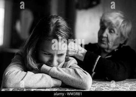 Nonna trecce capelli sconvolto bambina. Foto in bianco e nero. Foto Stock