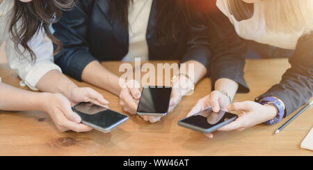 Vista ravvicinata del freelancer femmina la condivisione di informazioni sugli smartphone ad altri membri del team Foto Stock