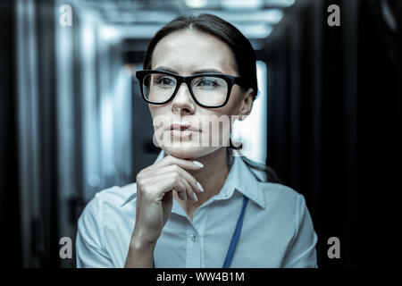 Dai capelli scuri da professionale agenzia di intelligence in occhiali guardando pensieroso Foto Stock