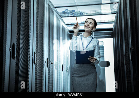Con i capelli lunghi donna in un mantello sentirsi appagato al lavoro Foto Stock