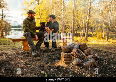 Giovane seduto da un falò in Molkom, Svezia Foto Stock