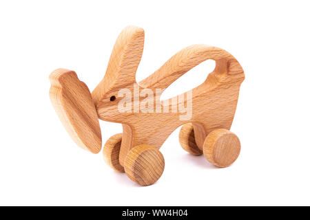 Foto di un coniglio di legno con la carota su ruote di faggio. Giocattolo di legno su un isolato bianco sfondo.Un giocattolo per il divertimento dei bambini e il riposo Foto Stock