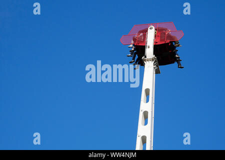 Le persone che si godono la corsa sulla caduta libera in attrazione lunapark Foto Stock