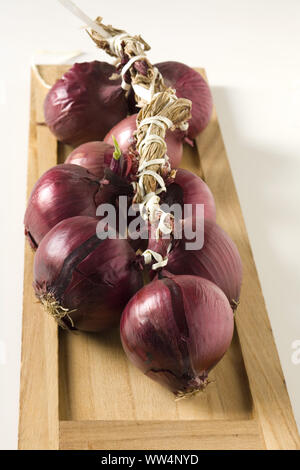 Cipolla rossa intreccio sul vassoio in legno Foto Stock