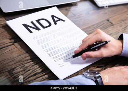 L'uomo firma accordo di non divulgazione in Office Foto Stock