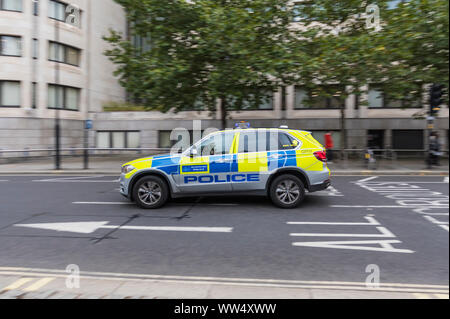 La Metropolitan Police automobile che viaggia alla velocità con luci blu nella City di Londra, Inghilterra, Regno Unito. Foto Stock