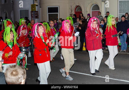 Donne abbigliate con vestiti con abiti fantasiosi marciando in una processione mentre a Guy Fawkes evento in Inghilterra, Regno Unito. Foto Stock