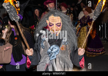 Qualcuno in fancy dress costume vestita come una strega in una processione mentre a Guy Fawkes evento in Inghilterra, Regno Unito. Foto Stock