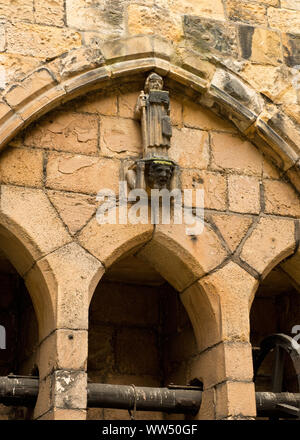 Piccola scultura del sacerdote nel cortile di Alnwick Castle. Northumberland, Inghilterra Foto Stock