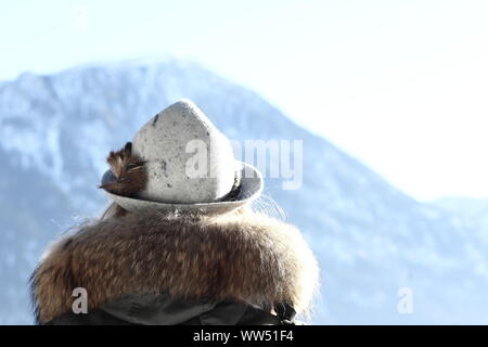 Giovane donna con tradizionale bavarese hat e pelliccia collare nel panorama alpino, Foto Stock