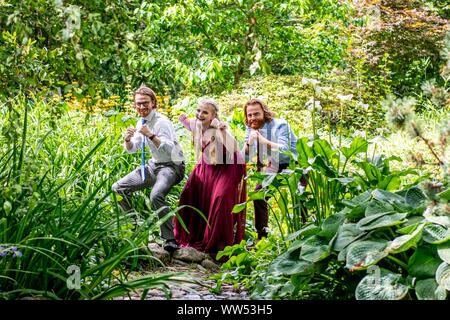 Tre fratelli in piedi in un giardino messing about, Canada Foto Stock