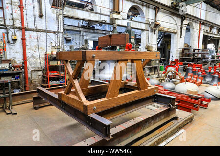 Una campana in un apposita culla di legno a John Taylor & Company fonderia di campane, Loughborough, Leicestershire, England, Regno Unito Foto Stock