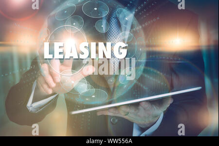 A mano selezionando un leasing il concetto di business su un avveniristico il display del computer. Foto Stock