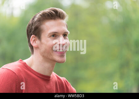 Uomo in maglione rosso, guardando dal lato, ritratto, Foto Stock