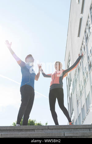 Matura in abbigliamento sportivo tifo permanente sulla sommità delle scale al di fuori Foto Stock