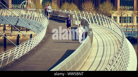 NEWCASTLE UPON TYNE, Regno Unito - 08 maggio, 2018: pendolari e turisti attraversando il Millennium Bridge nella luce del sole di mattina. Foto Stock