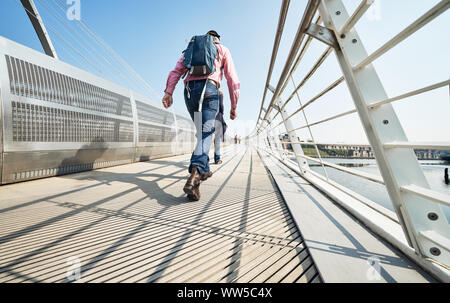 GATESHEAD, England, Regno Unito - 08 maggio, 2018: pedoni e pendolari che attraversa il Gateshead Millennium Bridge Foto Stock