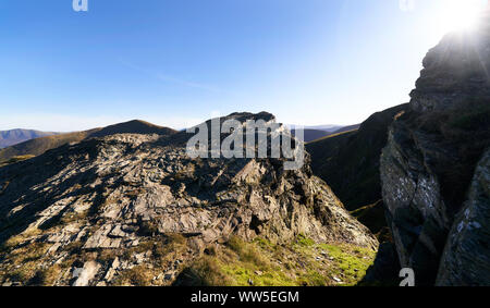 Guardando oltre la cresta rocciosa al di sotto della testa Hopegill verso Grisedale Pike in una giornata di sole nel Lake District inglese, UK. Foto Stock