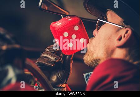 Feeling Lucky Casino Player Kissing impiccato nella sua auto Red Dado da gioco. Il tema del gioco d'azzardo. Foto Stock