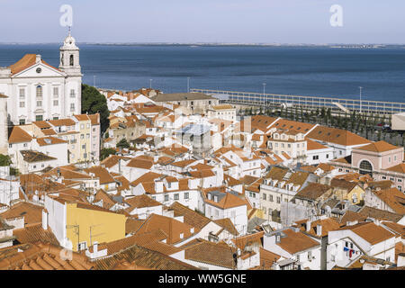 Vista del centro storico quartiere Alfama con il fiume Tagus in background in giornata soleggiata a Lisbona, Portogallo, dal trascurare di Portas do Sol Foto Stock