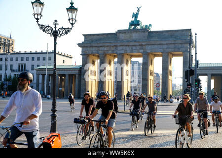 28.08.2019, Berlin, Germania: i ciclisti in ora di punta sulla piazza del XVIII marzo davanti alla Porta di Brandeburgo al mattino con bassa sun nel Foto Stock