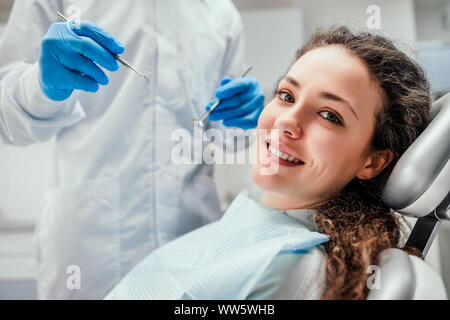 Sorridente giovane donna ricevere dental checkup. vista ravvicinata. La sanità e la medicina del concetto. Foto Stock