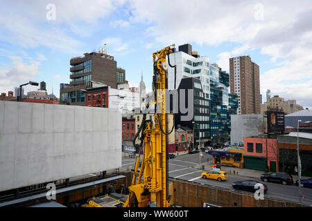 Un veicolo di ingegneria su un cantiere di fronte degli edifici moderni visto dalla linea alta. Chelsea, Manhattan, New York City. Foto Stock