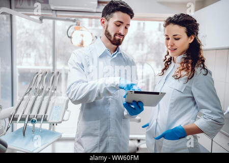 La sanità e la medicina concetto,due colleghi che stanno guardando sullo schermo del tablet. Foto Stock