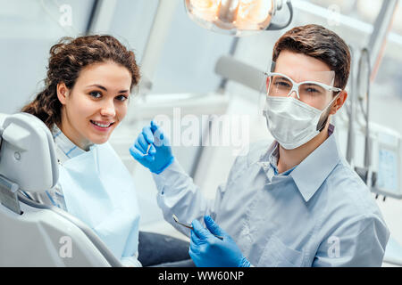 Giovane donna avente check up e esame dentale al dentista. Vista laterale. Foto Stock