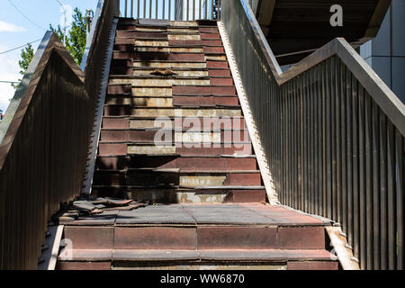 Scala danneggiato. Vecchia scala nella metropoli. Rotture di scale su per una rampa di scale Foto Stock