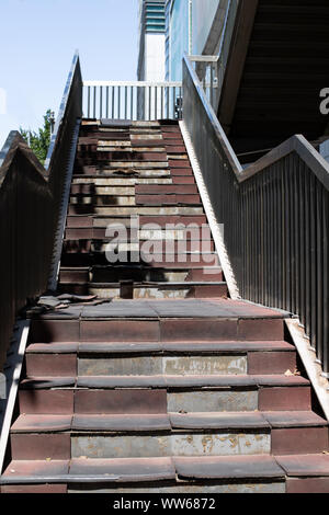 Scala danneggiato. Vecchia scala nella metropoli. Rotture di scale su per una rampa di scale Foto Stock