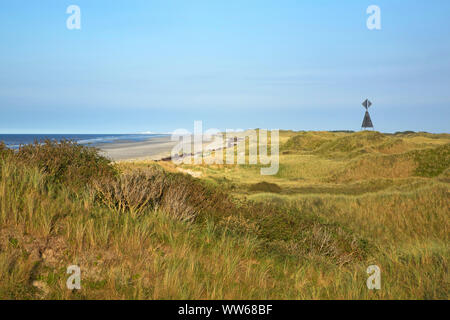 Vista del HaaksdÃ¼nen oltre il mare del nord Isola Juist. Sulla destra il west il faro a luce rotante. All'orizzonte il luogo Norderney. Foto Stock