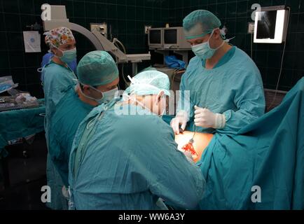 Lubin, Polonia. 26 Febbraio, 2009. Ospedale comunale in Polonia - una anastomosi del femore e un 62-anno-vecchia donna che si è infortunato come risultato di scivolare su una pavimentazione sdrucciolevole. L'osso rotto completamente. La chirurgia della coscia è stato necessario per motivi medici. Le ossa dopo anastomosi sono state applicate e avvitata piastre speciali. L operazione è durata circa 3 ore. Il paziente era pienamente consapevole perché l'operazione è stata eseguita sotto anestesia intratecale. Il team è costituito da 4 medici e 4 infermieri Credito: Piotr Twardysko-Wierzbicki/ZUMA filo/Alamy Live News Foto Stock