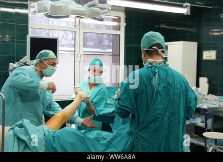 Lubin, Polonia. 26 Febbraio, 2009. Ospedale comunale in Polonia - una anastomosi del femore e un 62-anno-vecchia donna che si è infortunato come risultato di scivolare su una pavimentazione sdrucciolevole. L'osso rotto completamente. La chirurgia della coscia è stato necessario per motivi medici. Le ossa dopo anastomosi sono state applicate e avvitata piastre speciali. L operazione è durata circa 3 ore. Il paziente era pienamente consapevole perché l'operazione è stata eseguita sotto anestesia intratecale. Il team è costituito da 4 medici e 4 infermieri Credito: Piotr Twardysko-Wierzbicki/ZUMA filo/Alamy Live News Foto Stock