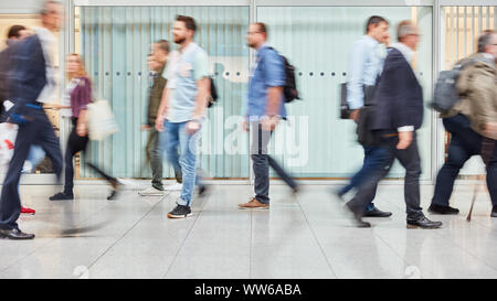 Anonimo offuscata la gente di affari sono a piedi attraverso un luminoso ufficio moderno Foto Stock