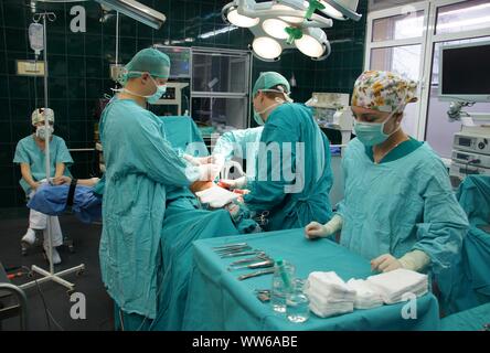 Lubin, Polonia. 26 Febbraio, 2009. Ospedale comunale in Polonia - una anastomosi del femore e un 62-anno-vecchia donna che si è infortunato come risultato di scivolare su una pavimentazione sdrucciolevole. L'osso rotto completamente. La chirurgia della coscia è stato necessario per motivi medici. Le ossa dopo anastomosi sono state applicate e avvitata piastre speciali. L operazione è durata circa 3 ore. Il paziente era pienamente consapevole perché l'operazione è stata eseguita sotto anestesia intratecale. Il team è costituito da 4 medici e 4 infermieri Credito: Piotr Twardysko-Wierzbicki/ZUMA filo/Alamy Live News Foto Stock