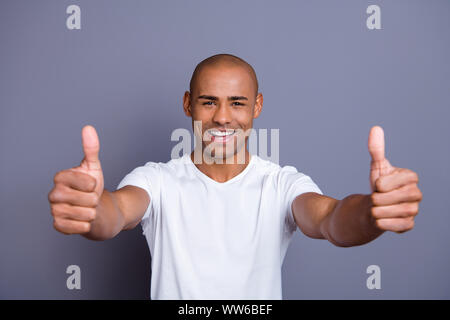 Close up foto forte dei denti sani la pelle scura ha di lui il suo ragazzo testa calva approvare visualizza miniature le dita su consigliare acquistare acquirente nuovo prodotto indossando white t Foto Stock