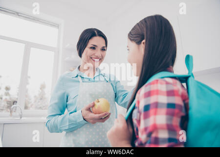 Ritratto di due belle carino adorabile attraente bella affascinante gente allegra coppia tipo attenta mamma rendendo dando pranzo snack alla luce cucina bianca Foto Stock