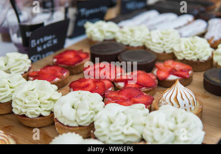 Riempito di sfondo con colorate torte e dessert con frutta fresca. Assortiti mini diverse torte con crema di cioccolato e frutti di bosco. Foto Stock