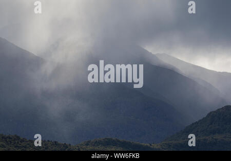 Nebbia, pioggia e nebbia circondano i fiordi e le colline di Doubtful Sound situato sull'Isola Sud della Nuova Zelanda Foto Stock