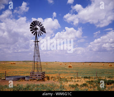 Negli anni ottanta la pompa di mulino a vento pieno il canale di irrigazione e di campo di balle di fieno blu cielo con PUFFY nuvole bianche al di sopra di una fattoria in Kansas USA - kf13933 VRE001 HARS NUVOLE STRUTTURA KS E GLI AGRICOLTORI PUFFY PRAIRIE A IN dei pascoli naturali colli rotante blue sky foraggi terreni di crescita attraverso le pale di mulino a vento BALLE CUMULUS Great Plains MIDWEST MIDWESTERN in vecchio stile Foto Stock