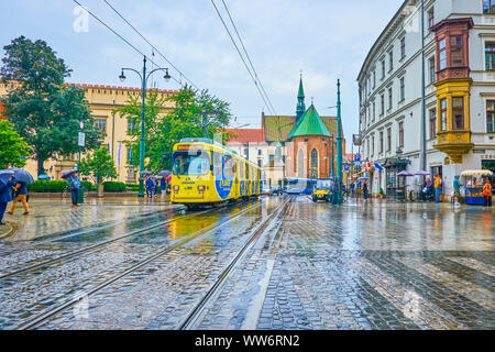Cracovia in Polonia - Giugno 13, 2018: il tram ride lungo tutte le Saint Square attraversando Grodzka, la principale strada turistica della città vecchia, il 13 giugno a Cracovia Foto Stock