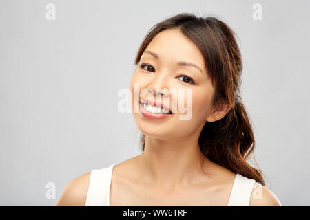 Faccia di sorridenti giovane donna asiatica Foto Stock