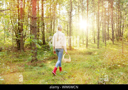Giovane donna la raccolta di funghi nella foresta di autunno Foto Stock