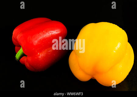 Ortaggi freschi due dolci giallo e peperoni rossi su sfondo nero.Close-up. Foto Stock