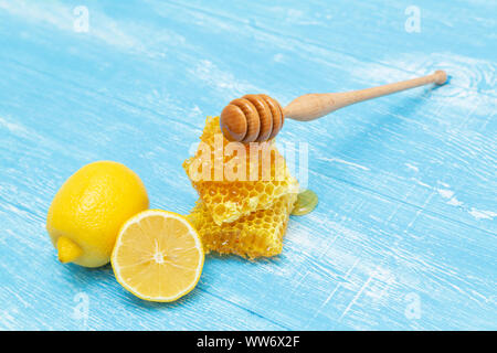 Favi e limone giacciono su un blu sullo sfondo di legno. Foto Stock